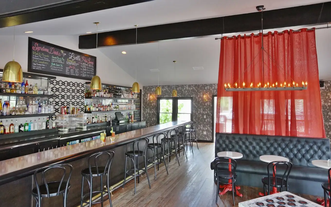 The long indoor bar with brass pendants and chalkboard cocktail menu