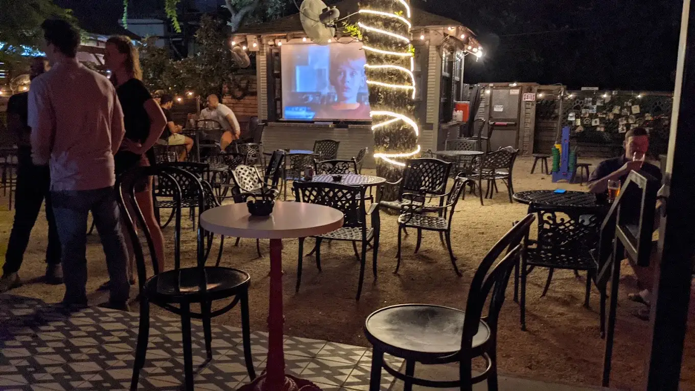 Movie night in Lucille's backyard with a projector screen and a lit-up tree
